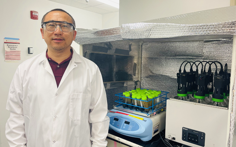 Faculty Member Guangbin Li pictured in his lab facing the camera