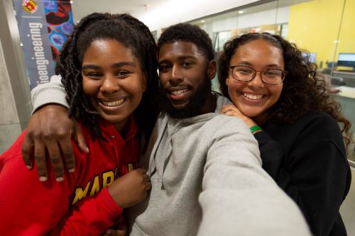 three black students standing together and wearing Maryland apperal