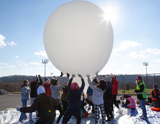 Students holding a large balloon