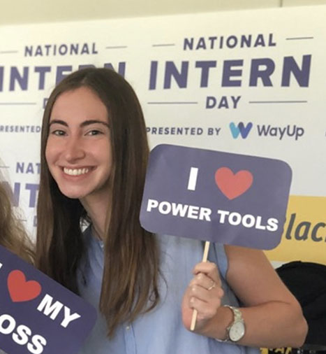 Erin Wernick holding an "I love power tools" sign 