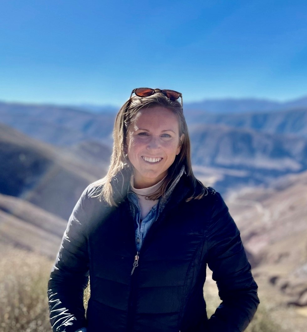 Staff member smiling in front of mountains