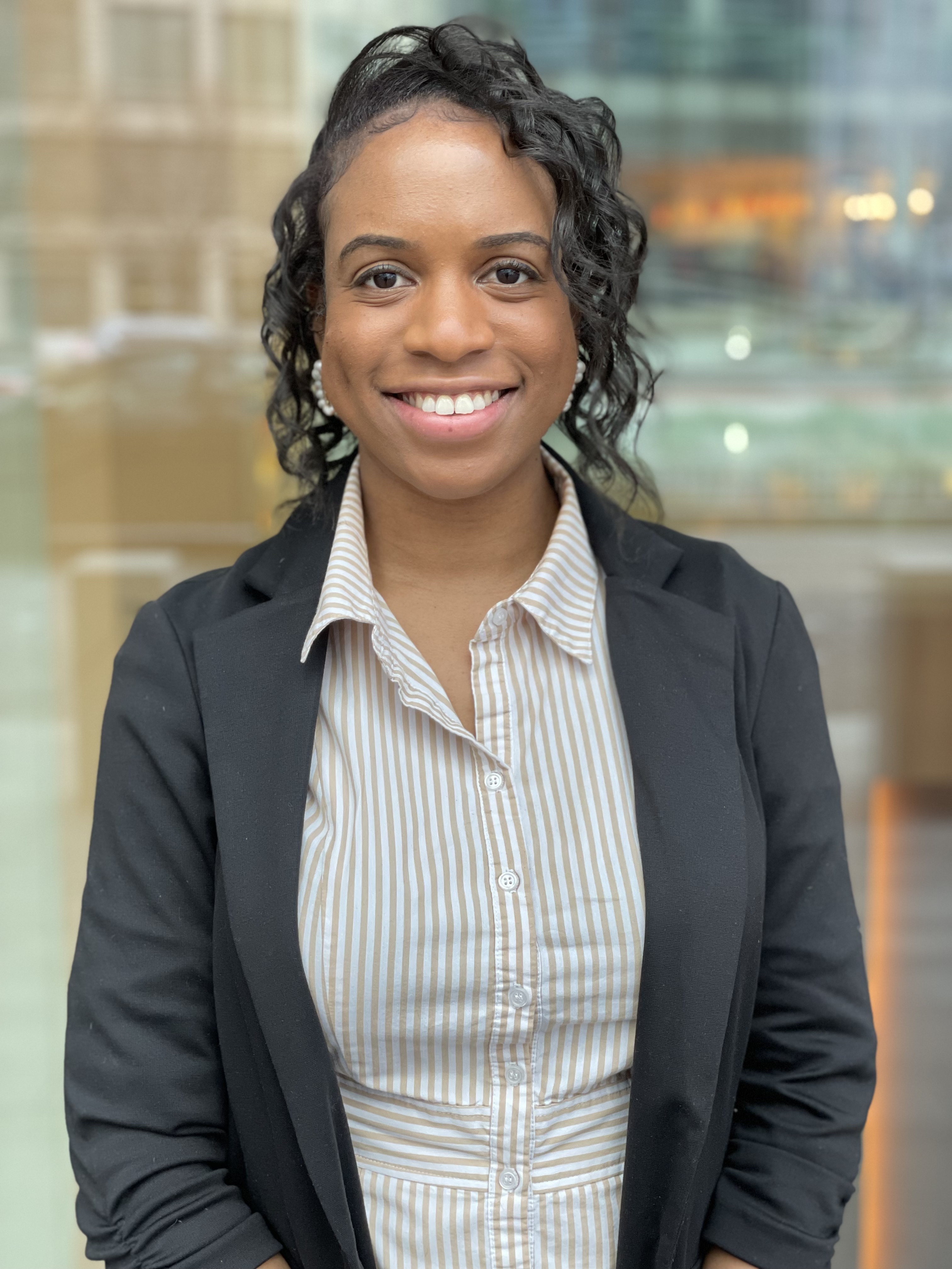 Niku Letang Headshot Niku Letang in a black suit jacket and a vertically striped button-up shirt.