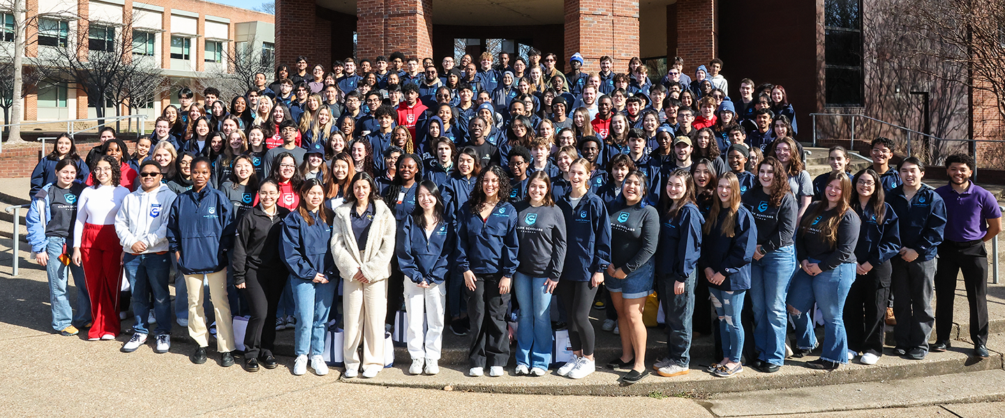 a group of Clark Scholars pose for a group photo on a  set of large steps outside