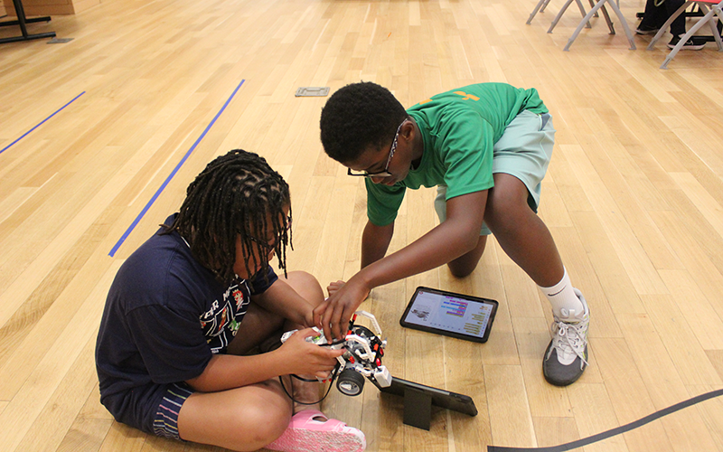 two male students working together to build a robot vehicle