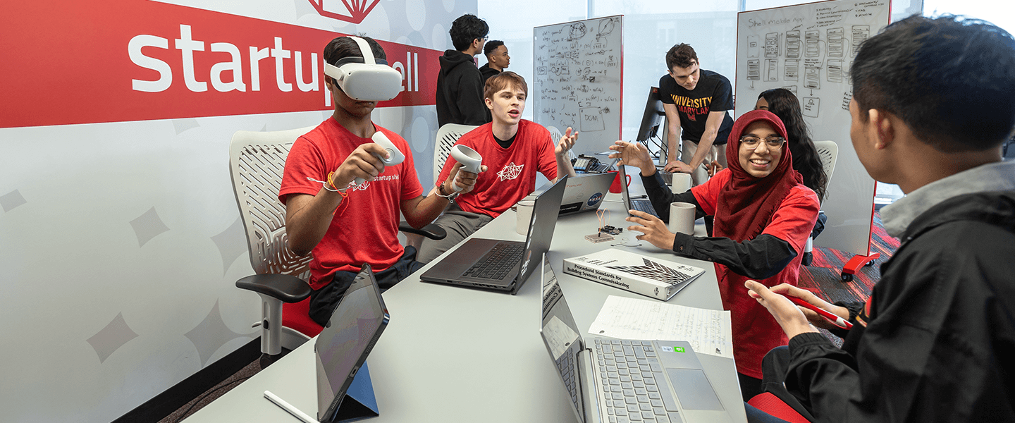 students sit a table in the Startup Shell testing a virtual reality device