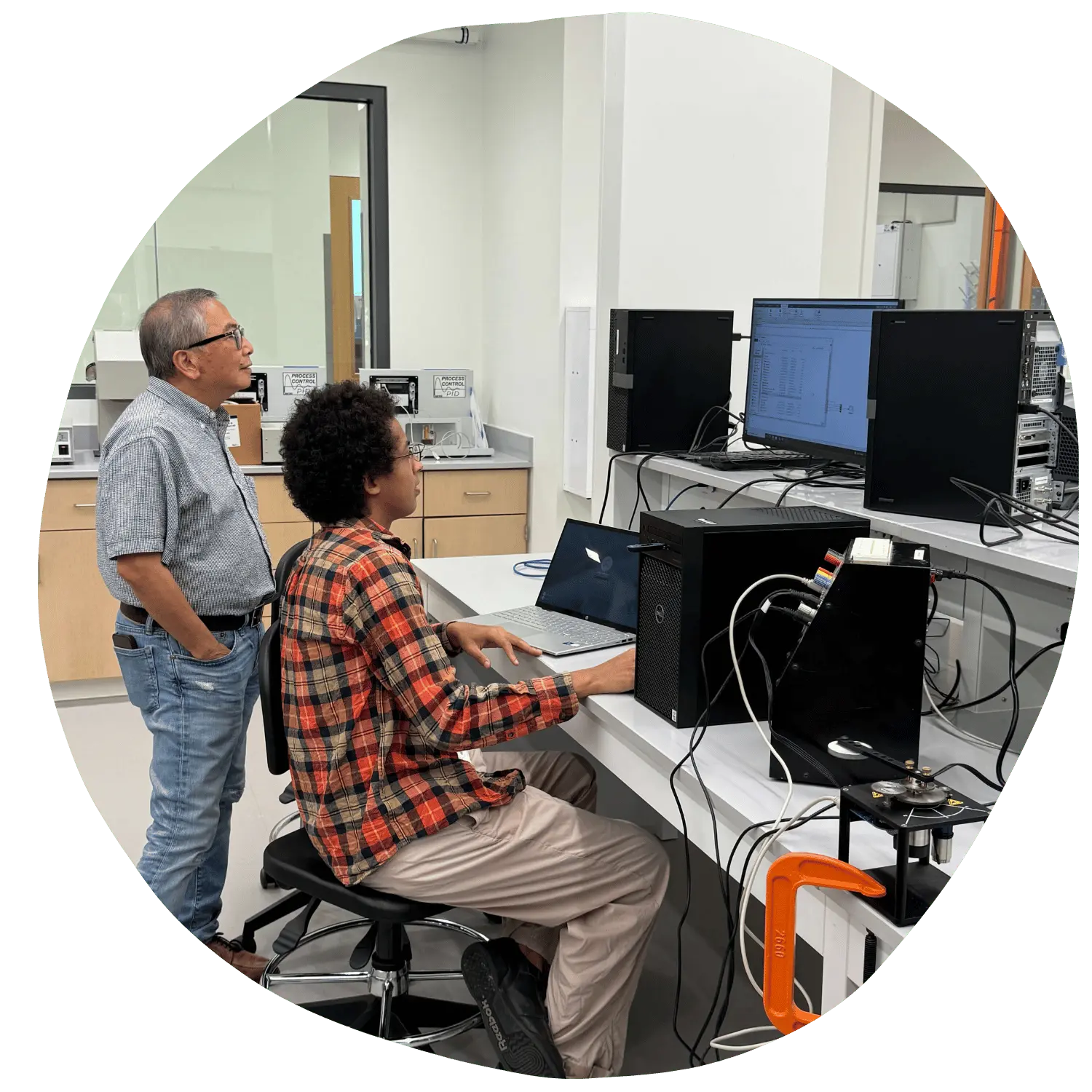 Faculty and student at a computer looking at the screen together.