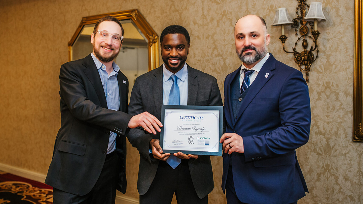 Damena Agonafer poses with a framed plaque for the Best Paper award at the Open Compute Project Global Summit&rsquo;s Future Technologies Symposium.