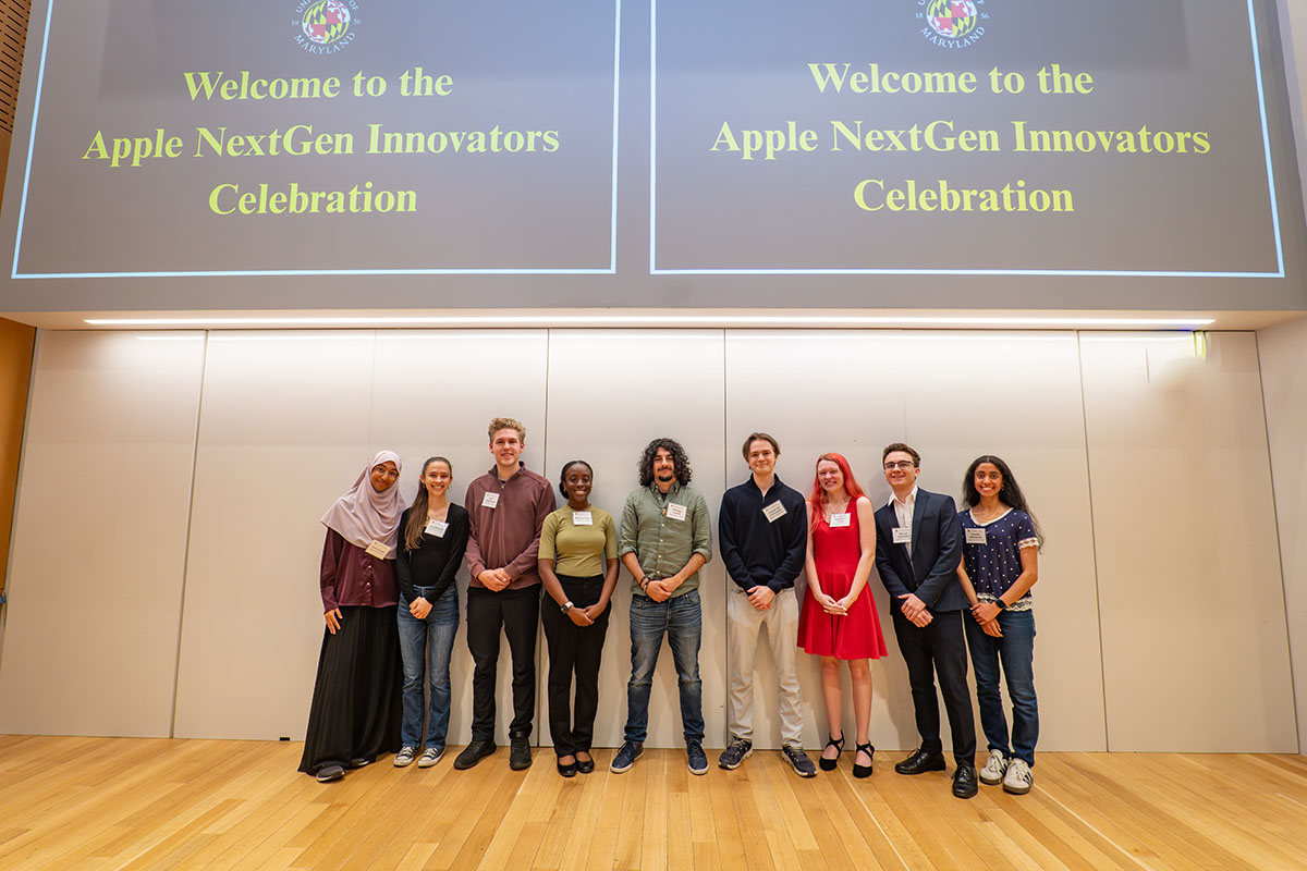 Nine students pose under a sign reading Welcome to the Apple NextGen Innovators Celebration
