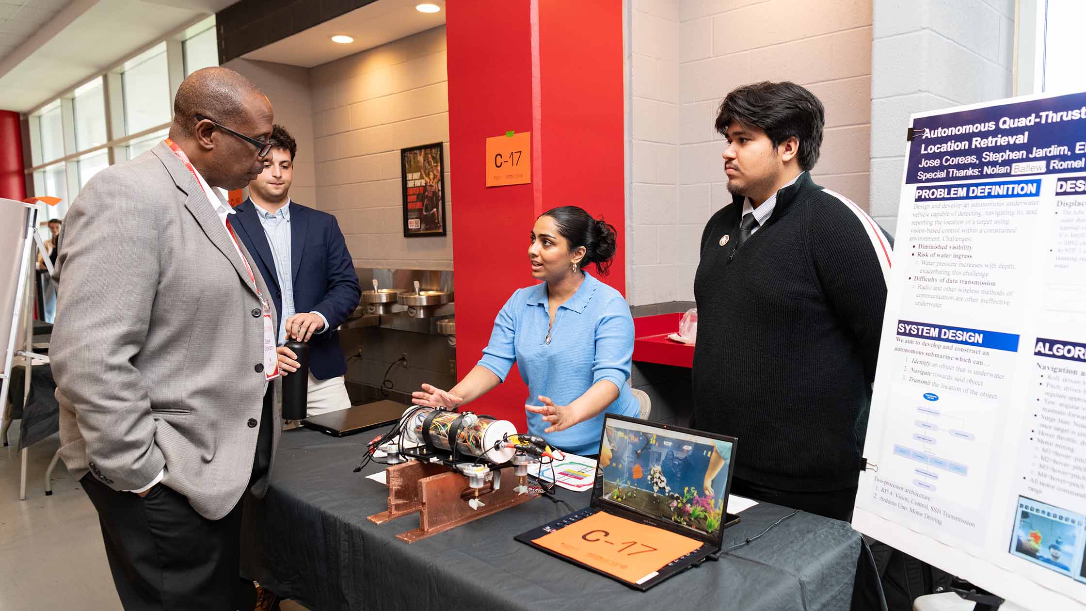 Two students present their research to the dean at the Capstone Design Expo
