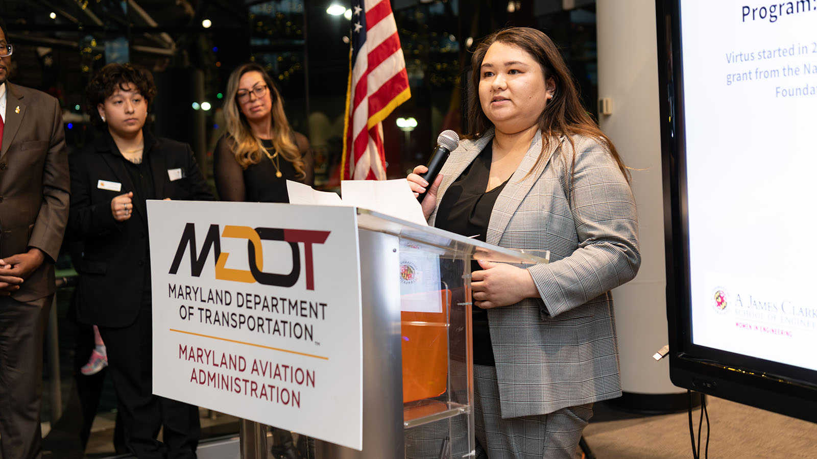 Chelsea Neumann Chelsea Neumann speaks from a lectern for Maryland Department of Transportation, Maryland Aviation Administration