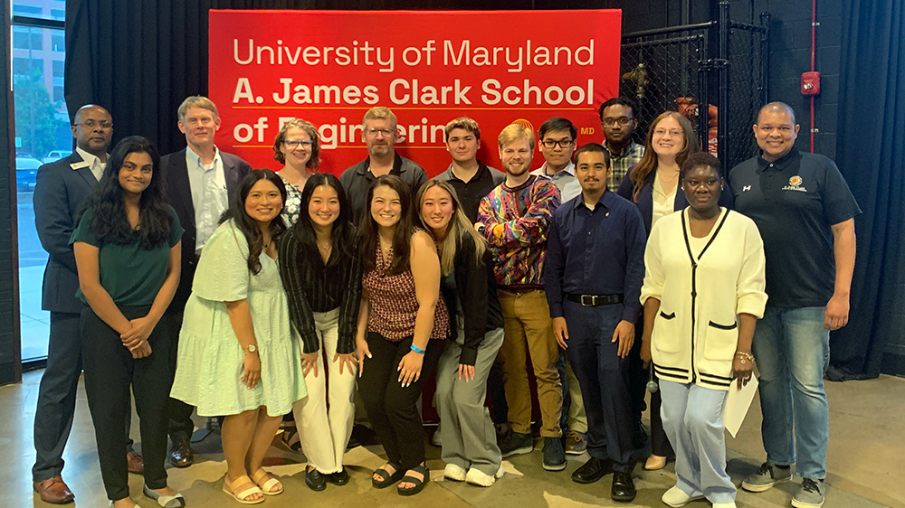 COTS and Clark Scholars pose in front of a UMD Clark School of Engineering banner