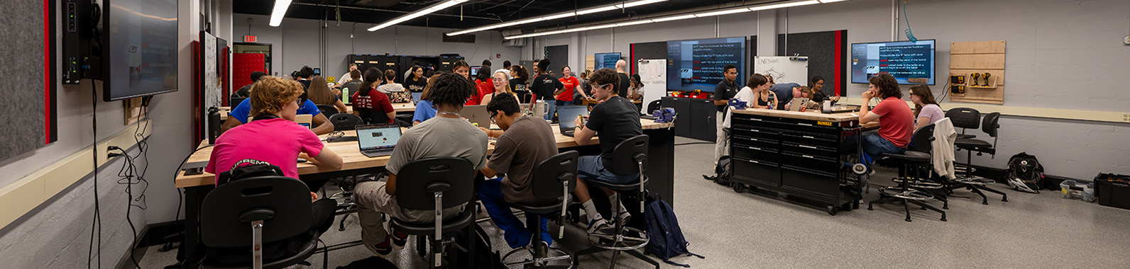 Students sit at workbenches inside an engineering classroom