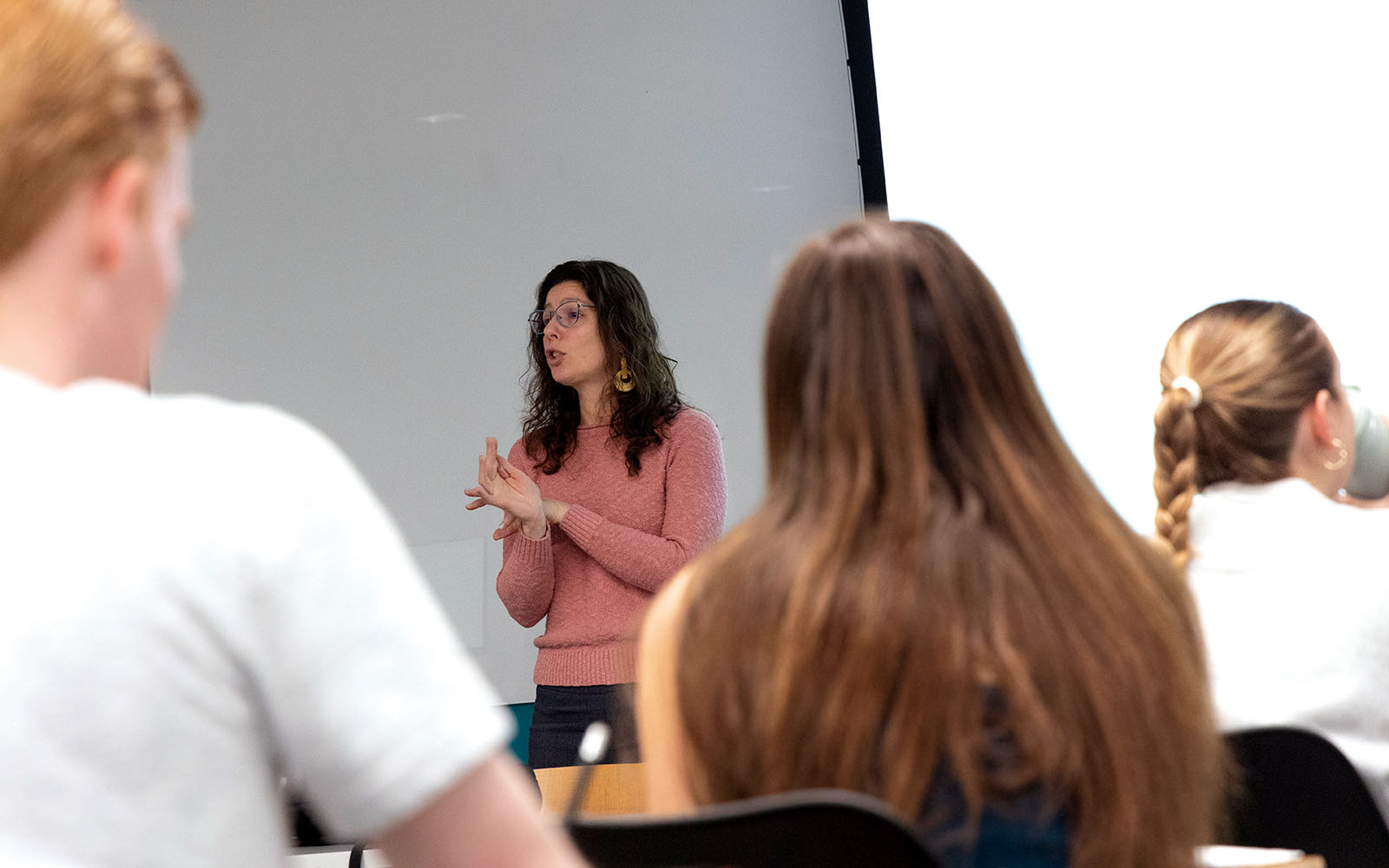 A teacher stands at the front of a classroom