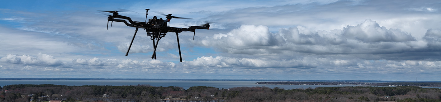 A drone in flight over farm land