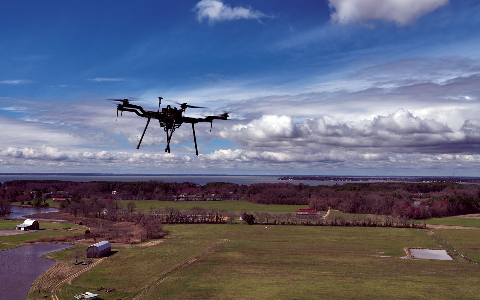 A drone in flight over farm land