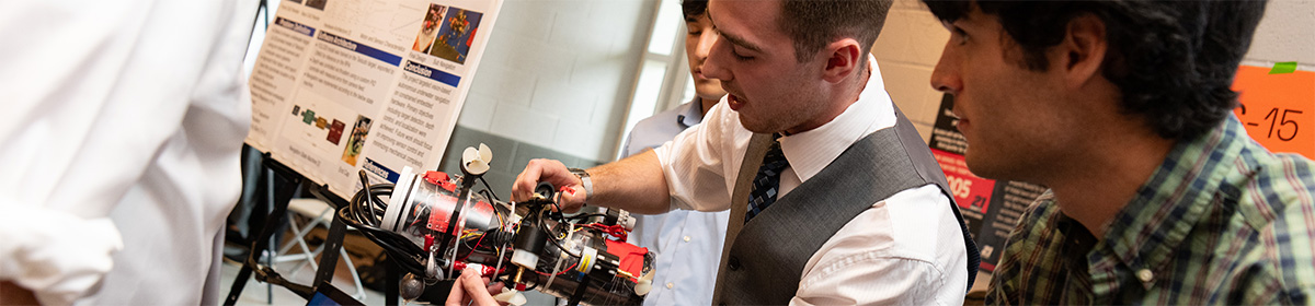 An ECE student explains his device to an attendee