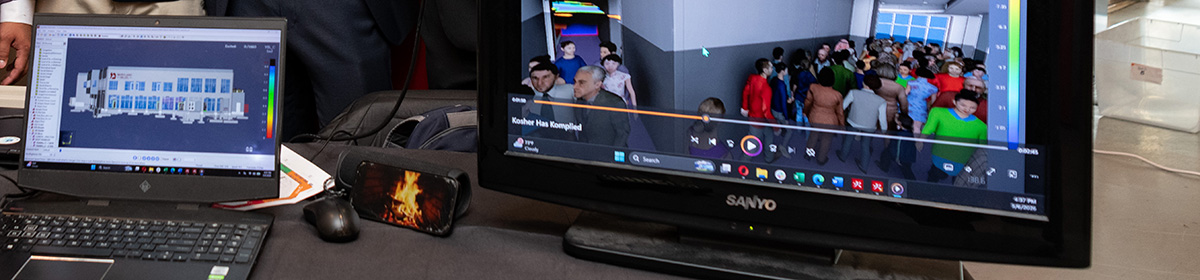 Close-up of a monitor showing a simulation of people evacuating a building