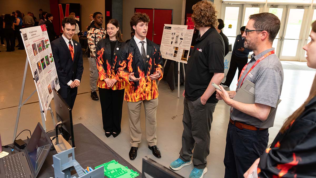 FPE students explain their project while standing by their research poster
