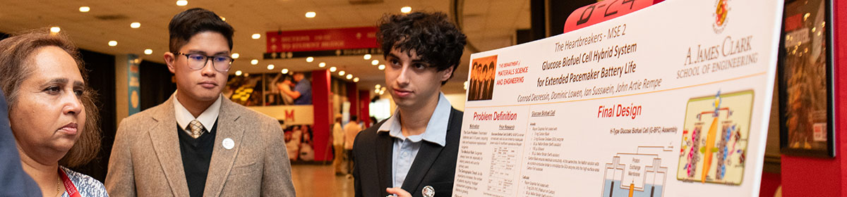 Three attendees look intently at a MSE research poster