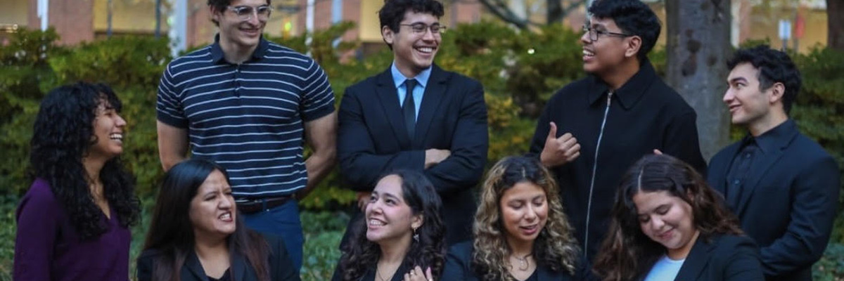 Nine students are dressed up and smiling outside