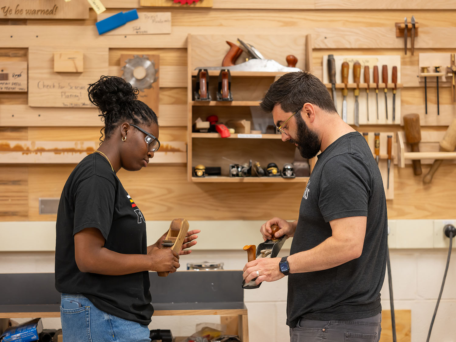Two people inspect tools in a makerspace