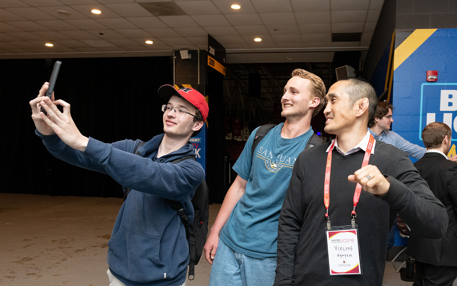 Two students take a photo with Vince Nguyen