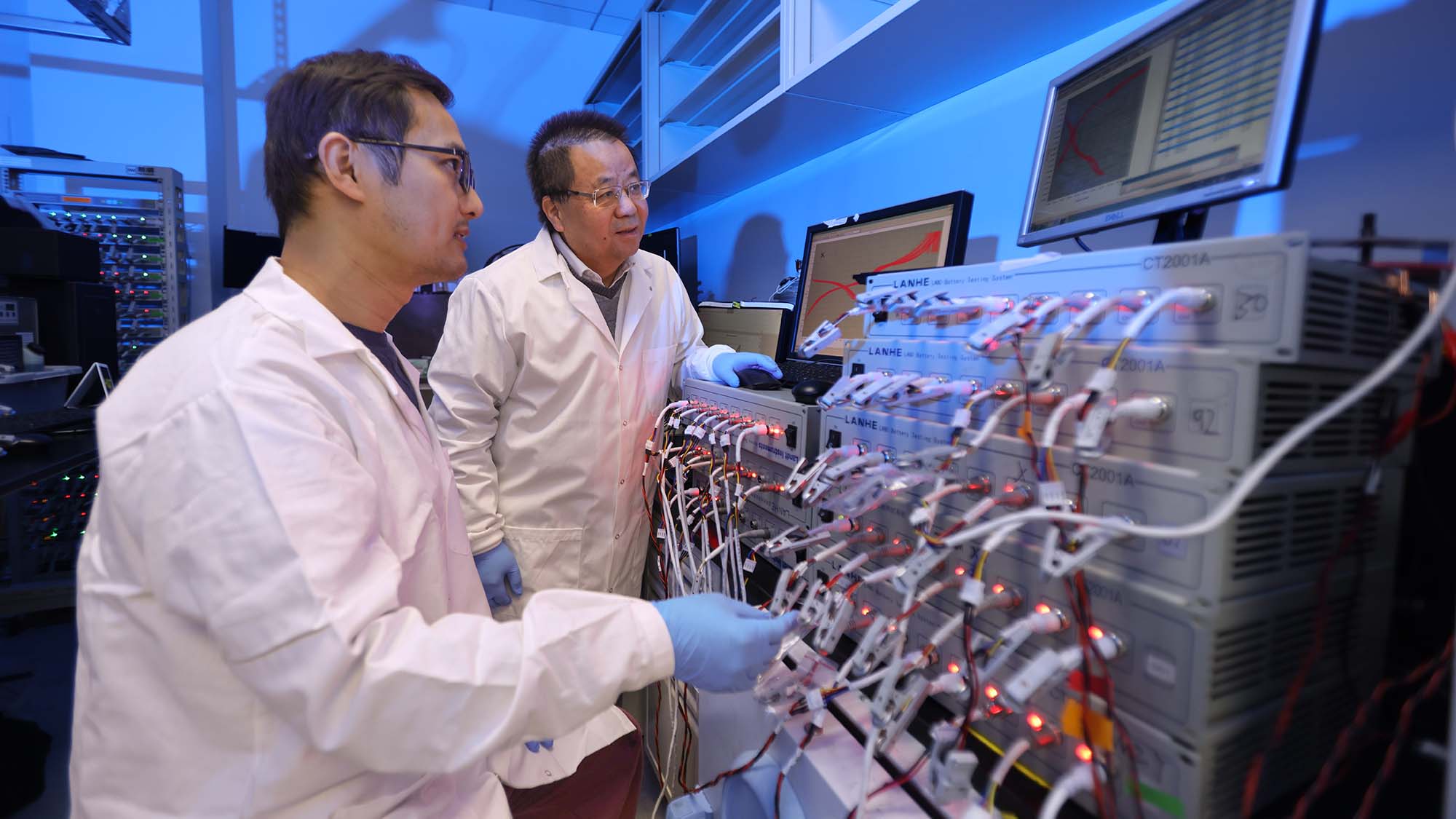 Two researchers in lab coats in a battery lab