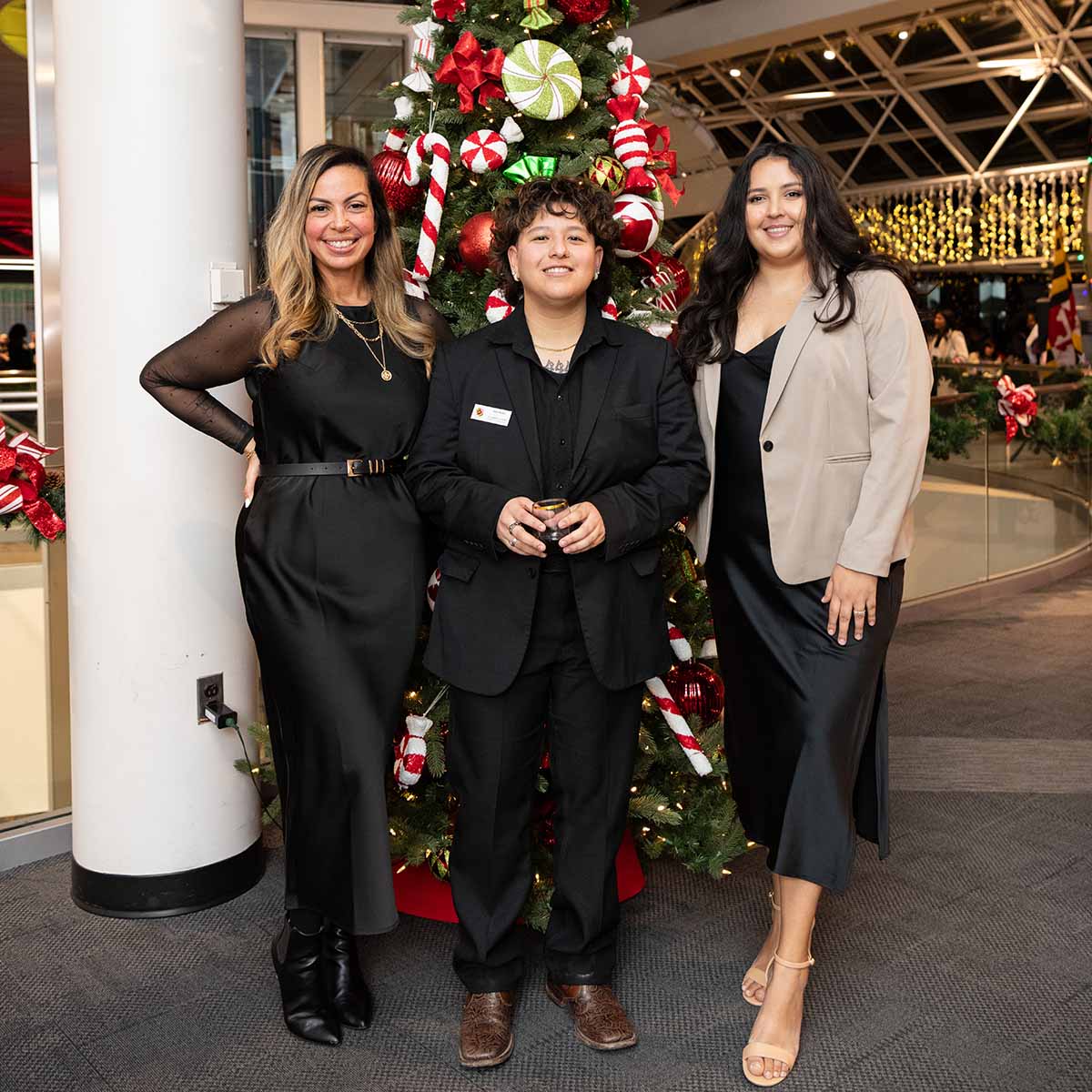 Cuadra Rodriguez with two colleagues in front of a decorated tree